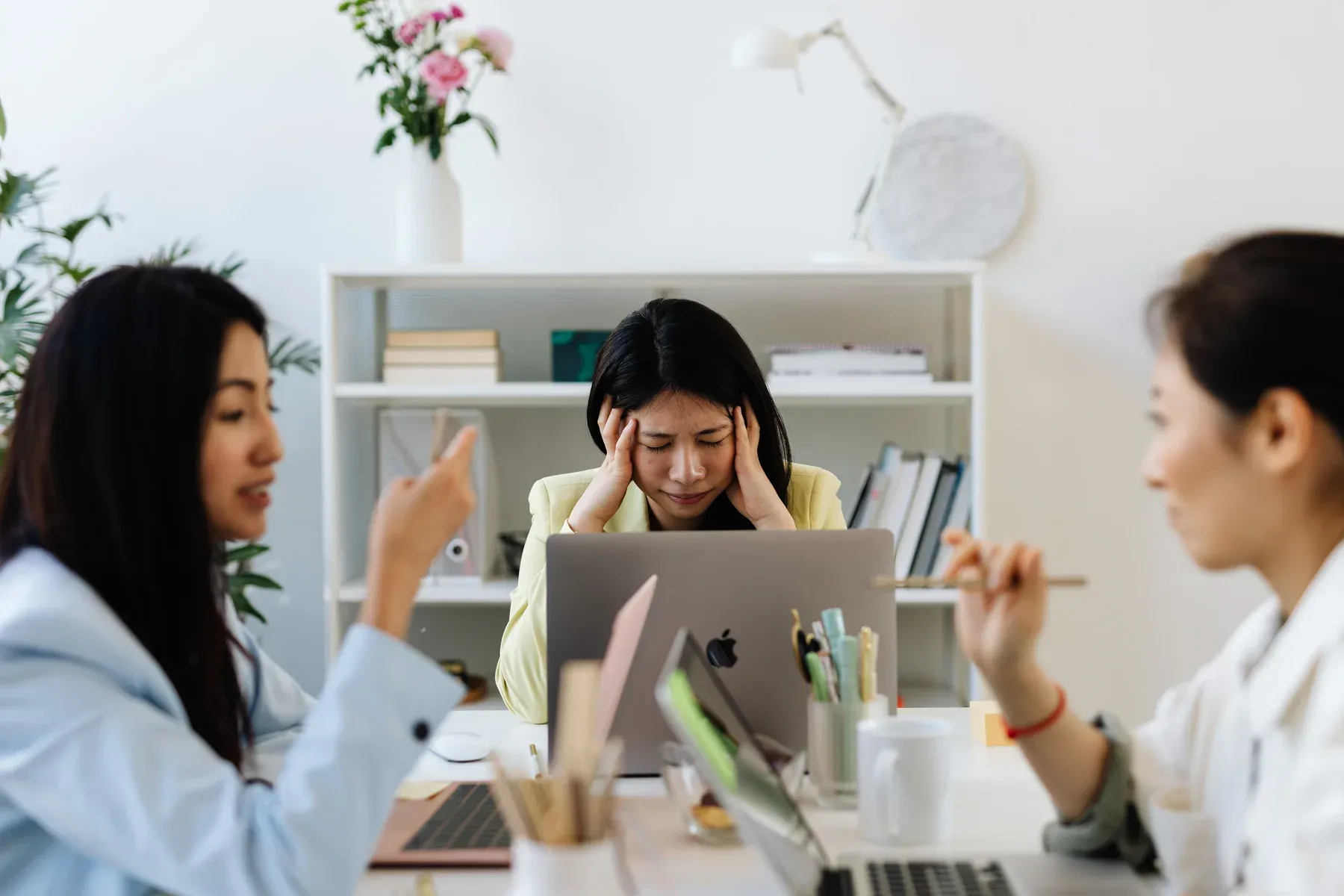 Chatswood office professional experiencing a tension headache and temple pressure from neck strain while working on a laptop