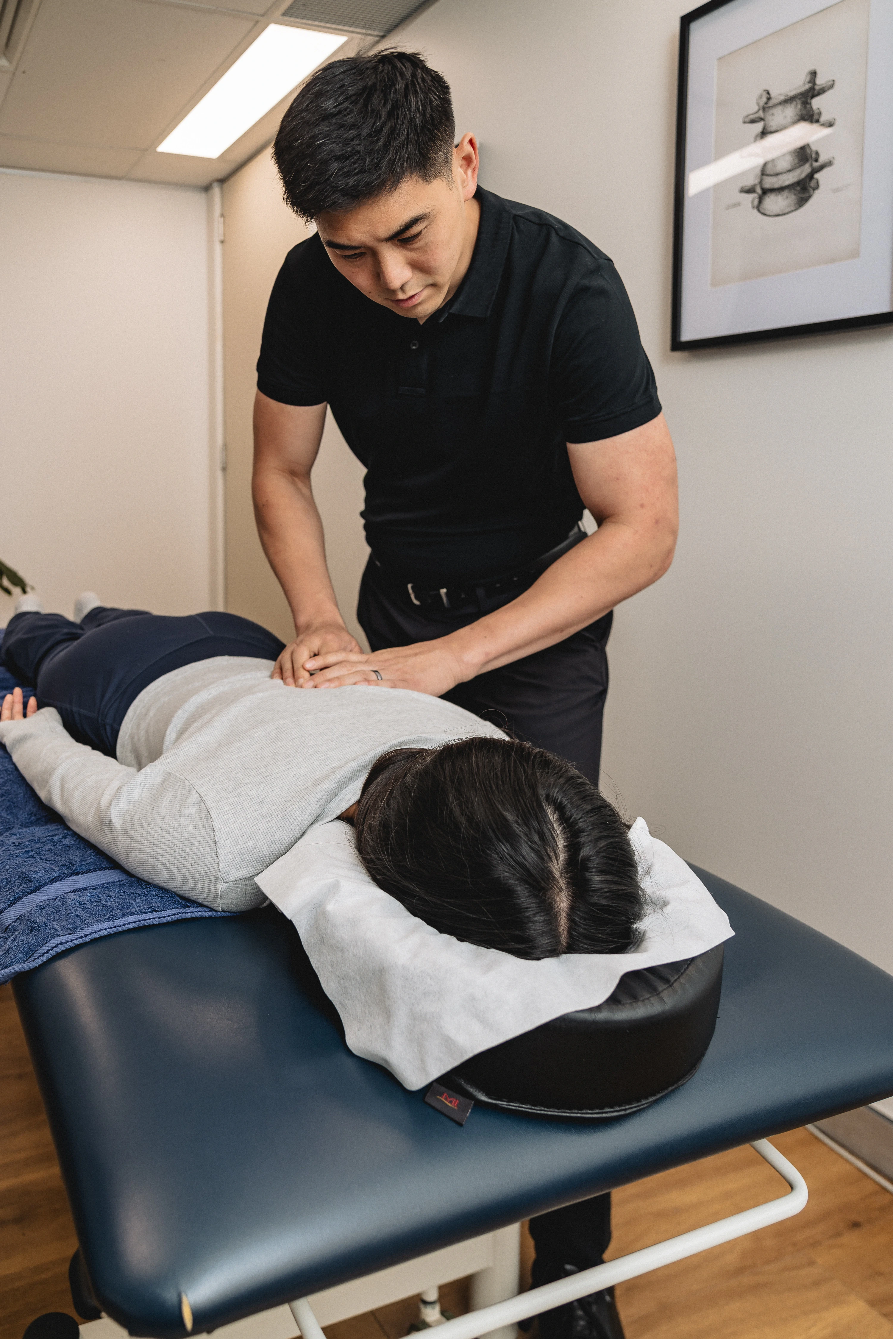 Chiropractor James Zheng providing hands-on treatment to a patient at the Chatswood clinic