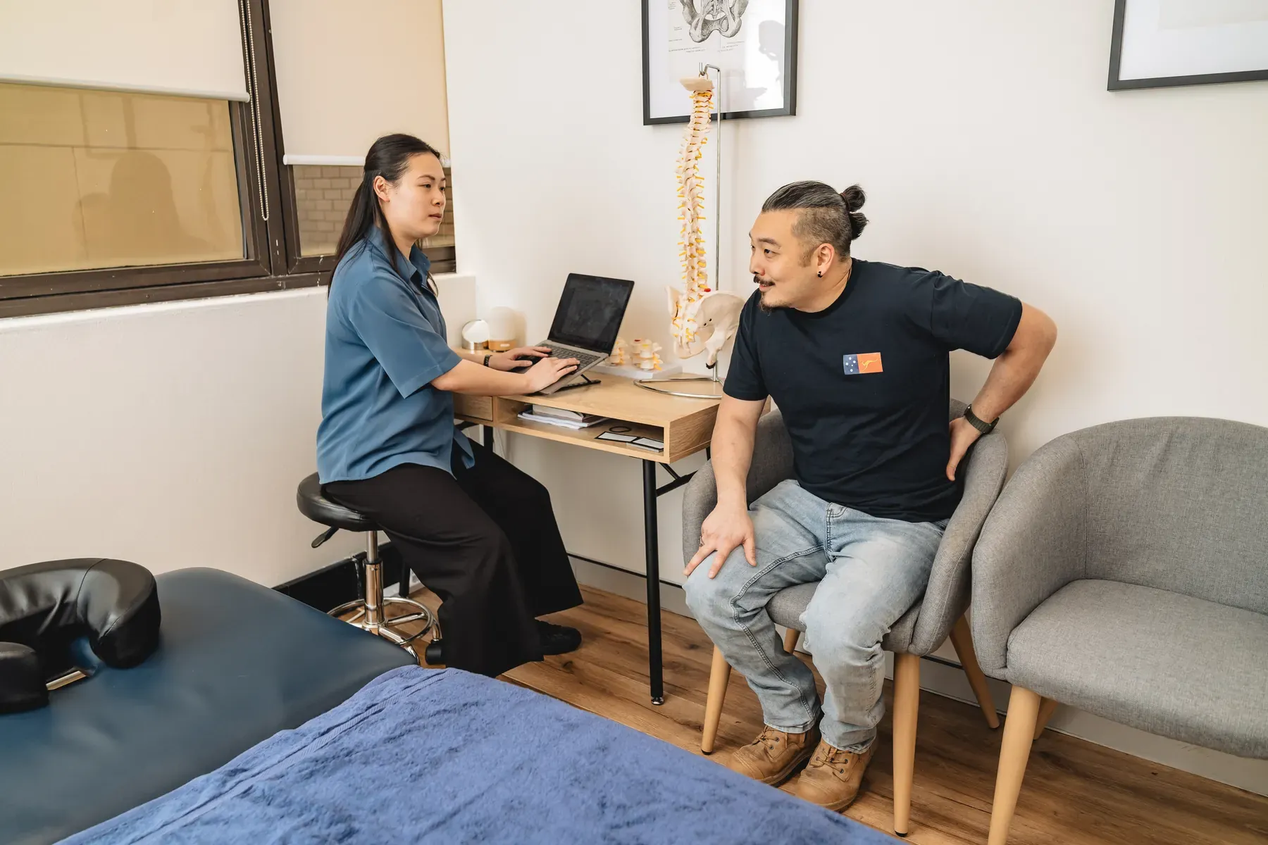 Practitioner talking with an adult patient in a consultation room at Body Therapy Chiropractic in Chatswood